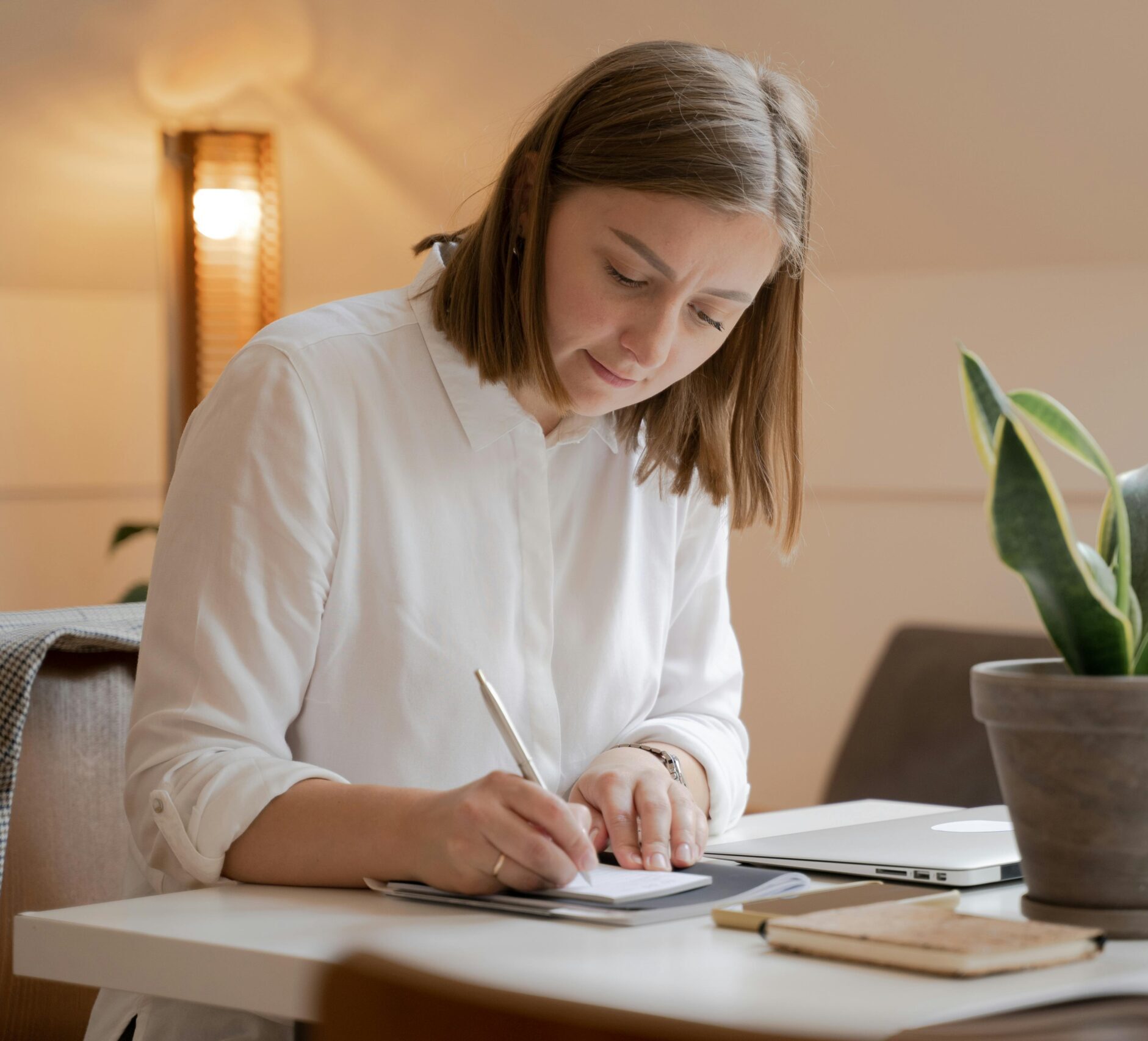woman sitting on a table writting down